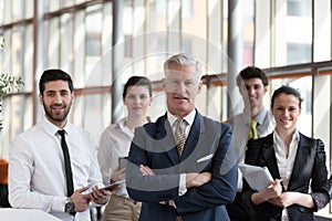 Portrait of senior businessman as leader with group of people i