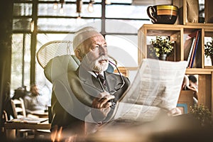 Portrait of senior businessman sitting at his office, ridding ne