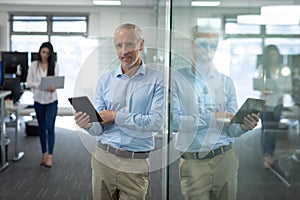 Portrait of senior businessman using digital tablet at modern office