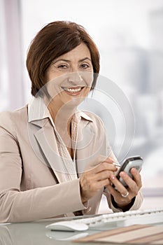 Portrait of senior businesswoman using pda