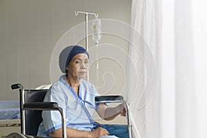 Portrait of senior cancer patient woman wearing head scarf in hospital, healthcare and medical concept