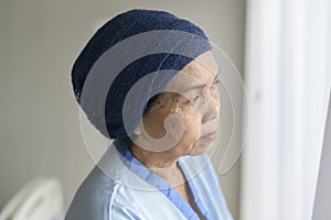 Portrait of senior cancer patient woman wearing head scarf in hospital, healthcare and medical concept