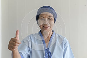 Portrait of senior cancer patient woman wearing head scarf in hospital, healthcare and medical concept