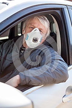 Portrait of senior car driver wearing dust mask to prevent coronavirus infection