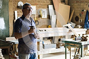 Portrait of senior carpenter. Standing in his workshop.