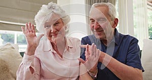 Portrait of senior caucasian couple smiling and waving to camera