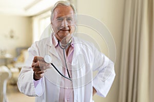 Portrait of senior caucasian male doctor holding stethoscope looking at camera