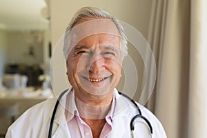 Portrait of senior caucasian male doctor looking at camera and smiling