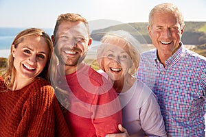 Portrait Of Senior Couple With Adult Offspring On Vacation By The Sea