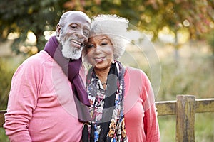 Portrait Of Senior Couple On Autumn Walk In Countryside Together