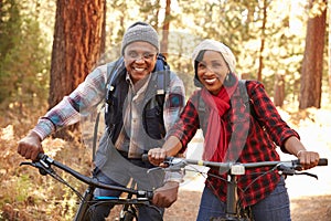 Portrait Of Senior Couple Cycling In Fall Woodland