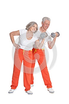 Portrait of senior couple exercising on white background