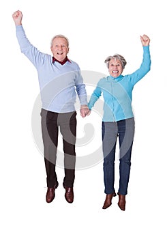 Portrait of senior couple jumping in joy