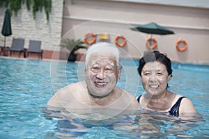 Portrait of senior couple relaxing in the pool