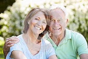 Portrait Of Senior Couple Sitting In Summer Garden Together