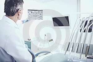 Portrait of a senior dentist analising x-ray in dental clinic