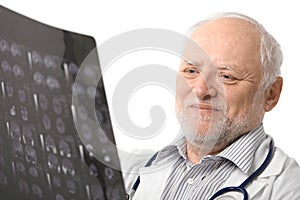 Portrait of senior doctor looking at X-ray image