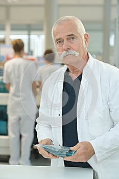 Portrait senior doctor standing at hospital