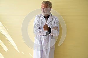 Portrait of senior doctor standing and showing thumb up at hospital,Happy and smiling positive thinking attitude,Copy space for te