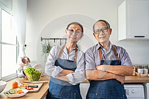 Portrait of senior elderly couple wear apron smiling, look at camera. Attractive strong older man and woman grandparent wear