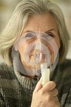 Portrait of a senior elderly woman with inhaler