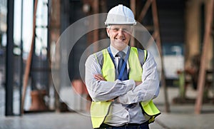 Portrait of senior engineer man at a construction site outdoor for building project management. Face of happy contractor