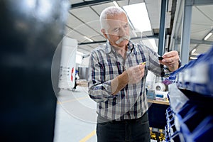 portrait senior factory worker in industrial workshop