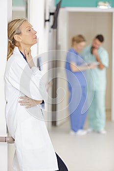 portrait senior female doctor on hospital corridor relaxing
