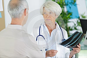 portrait senior female doctor with patient