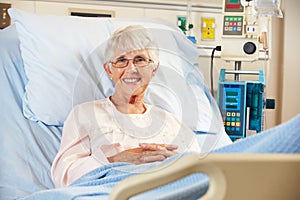 Portrait Of Senior Female Patient Relaxing In Hospital Bed