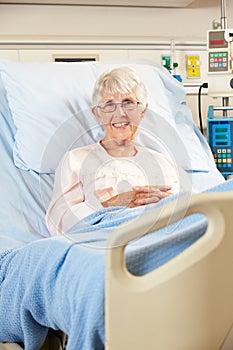 Portrait Of Senior Female Patient Relaxing In Hospital Bed