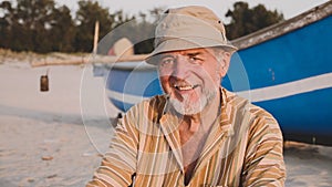 Portrait of senior fisherman in hat near his fishing boat - Sicily