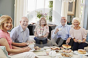 Portrait Of Senior Friends Enjoying Afternoon Tea At Home