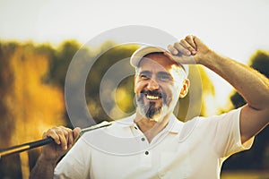 Portrait of senior golfer standing on court