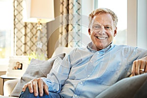 Portrait, senior or happy man in living room on couch or sofa to relax with freedom at home for resting break. Laughing