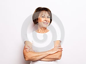 Portrait of senior happy woman with cute smile standing with his arms crossed over white background