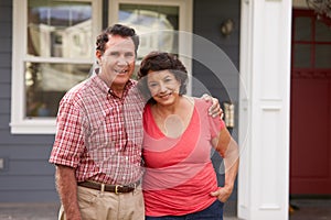 Portrait Of Senior Hispanic Couple Standing Outside House