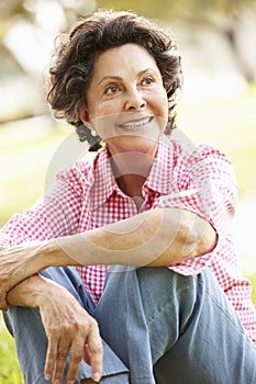 Portrait Of Senior Hispanic Woman Sitting In Park