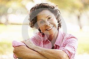 Portrait Of Senior Hispanic Woman Sitting In Park