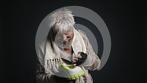 Portrait of a senior, homeless person counting his money