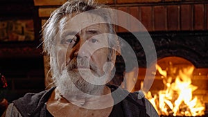 Portrait senior man alone at home near the fireplace