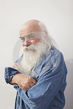 Portrait of senior man with arms crossed over gray background