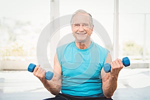 Portrait of senior man exercising with dumbbells