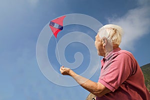 Portrait of senior man flying kite