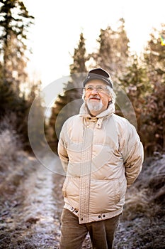 Portrait of senior man in a forest on a winter day