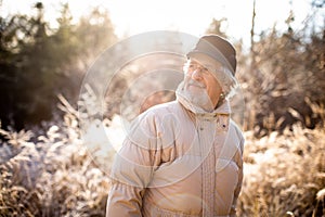 Portrait of senior man in a forest on a winter day