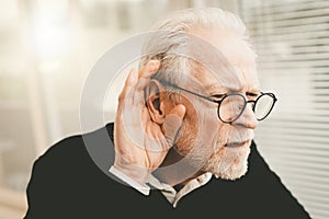 Senior man with hearing problems photo