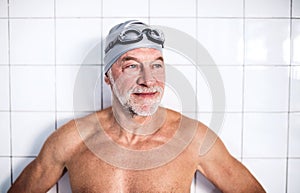 Portrait of a senior man in an indoor swimming pool.