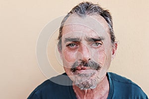 Portrait of senior man looking at camera with yellow background - Focus on face