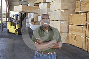 Portrait Of A Senior Man With Man Driving Forktruck In The Background